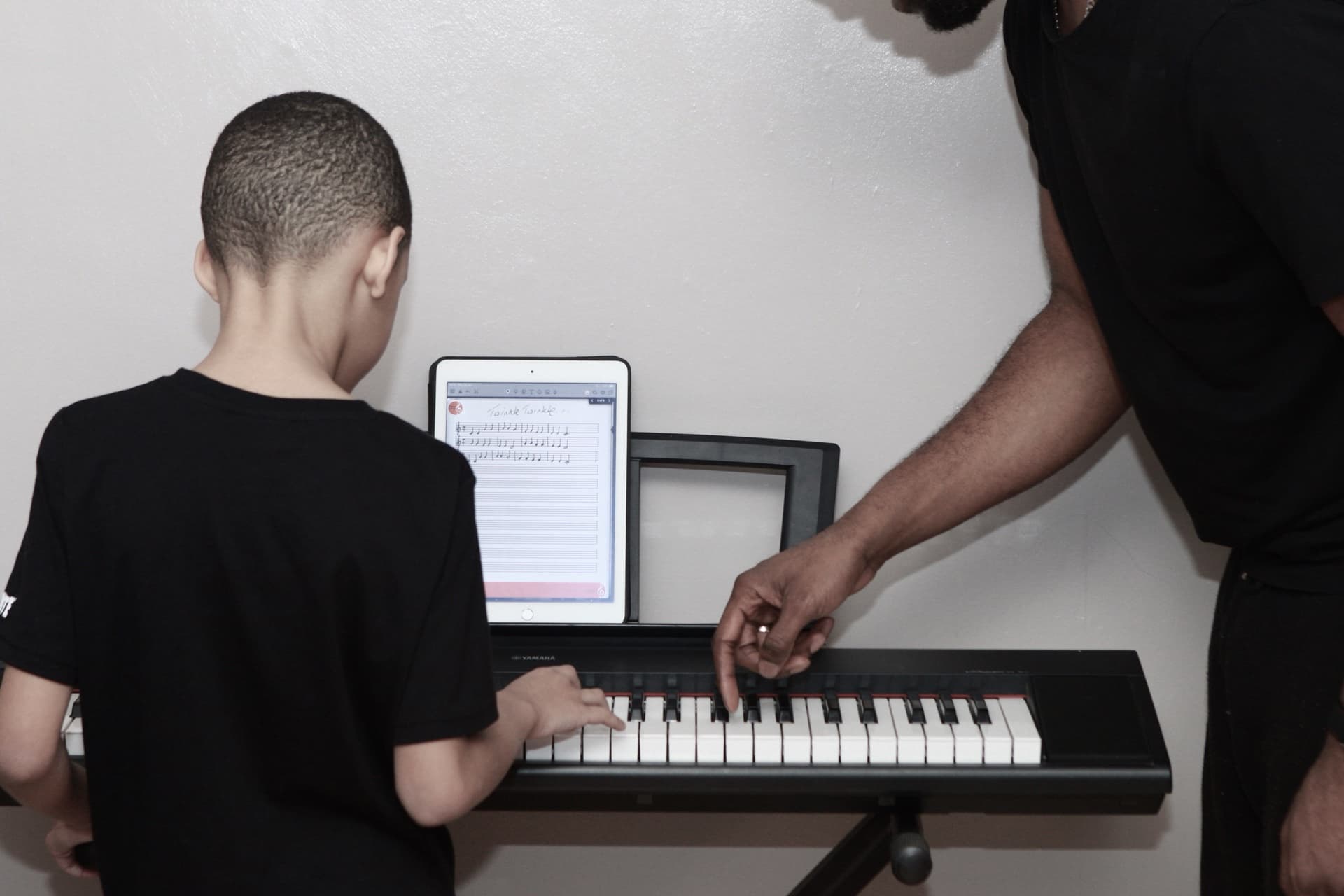 Teacher guiding a student at the keyboard — Kynda Learning, South London