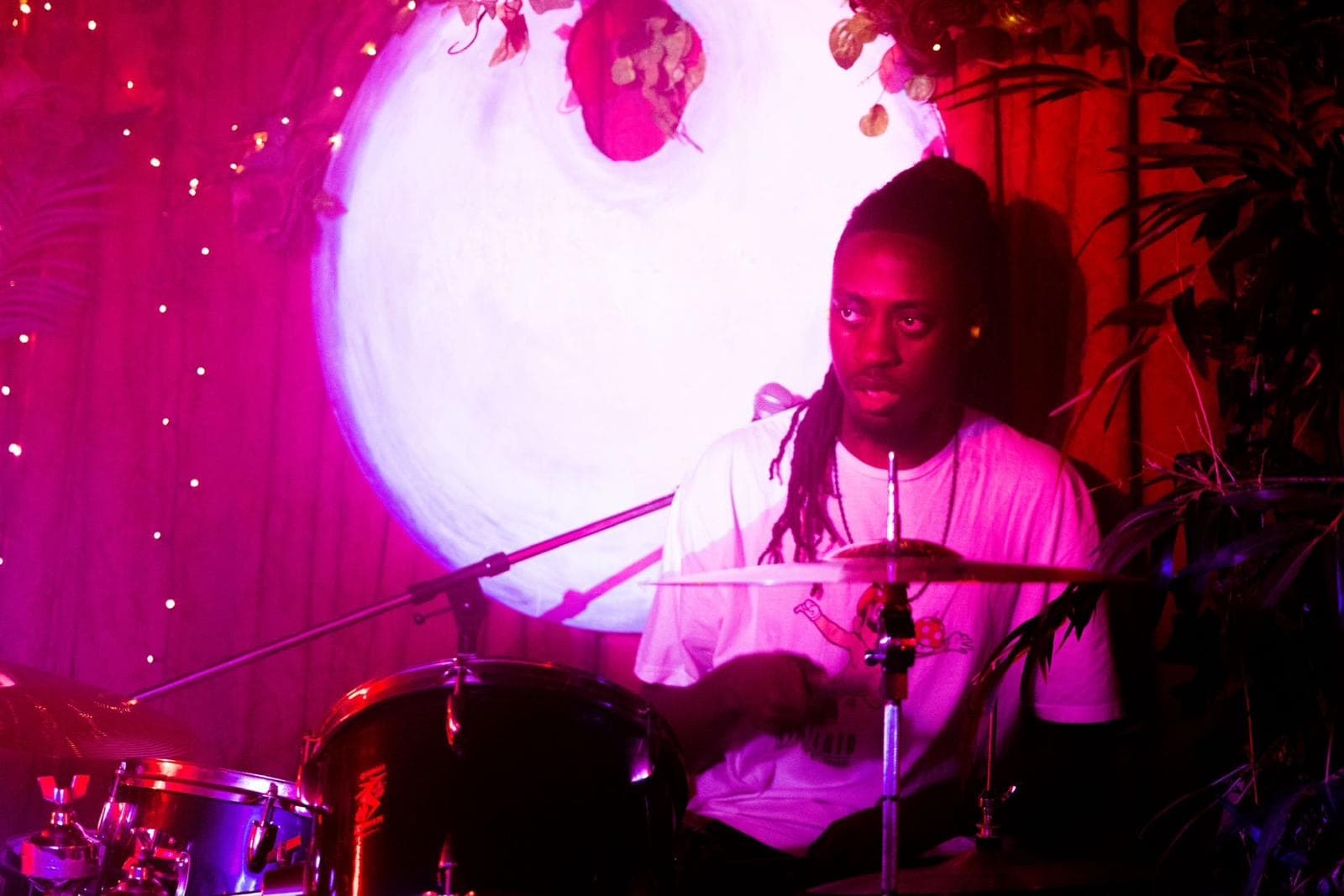 Jagun drumming at a live gig under red lights