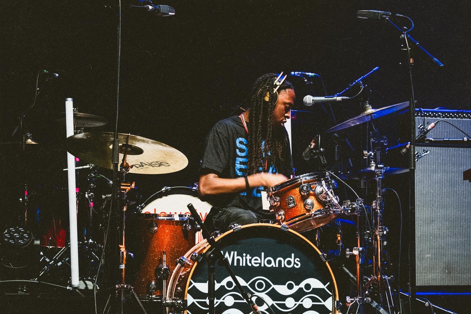 Jagun, Drum Lab facilitator, playing drums on stage with Whitelands